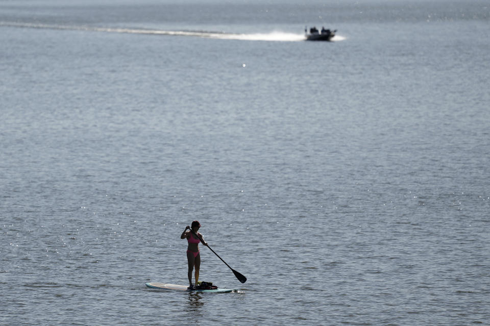 FILE - A woman rows her paddleboard as she takes advantage of warm temperatures Sunday, Feb. 25, 2024, on Smithville Lake near Paradise, Mo. Federal meteorologists on Friday, March 8, have made it official: It's the warmest U.S. winter on record by far. (AP Photo/Charlie Riedel, File)