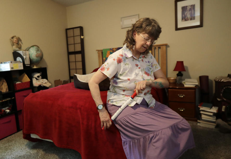 In this Aug. 22, 2018 photo, April Box uses a roller to work on her hip muscles at her home in Spokane, Wash. Millions of people covered under the Affordable Care Act will see only modest premium increases next year, and some will get a price cut. That’s the conclusion from an exclusive analysis of the besieged but resilient program that still divides voters heading into this year's midterm elections. (AP Photo/Ted S. Warren)