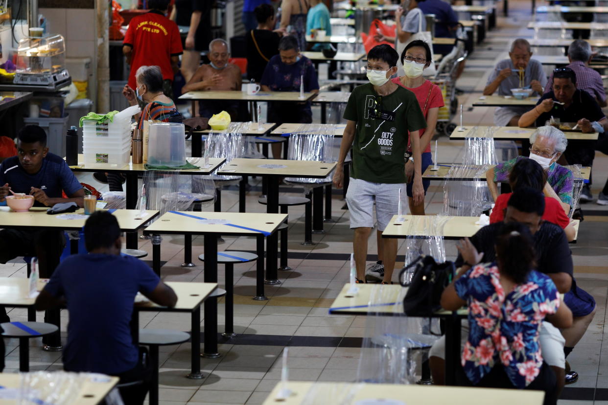 People eat at a hawker centre during the coronavirus disease (COVID-19) outbreak, in Singapore September 21, 2021. REUTERS/Edgar Su