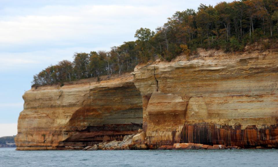 Beautiful colors are seemingly painted on the sandstone cliffs of Pictured Rocks National Lakeshore in Munising, Michigan. The colors are caused by layers and seepage of copper, iron and manganese in the ancient rock.