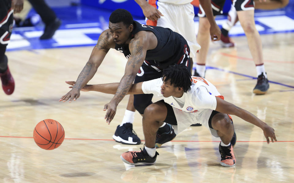 South Carolina guard Jermaine Couisnard dives over Florida guard Tyree Appleby for the ball during the second half of an NCAA college basketball game Wednesday, Feb. 3, 2021, in Gainesville, Fla. (AP Photo/Matt Stamey)