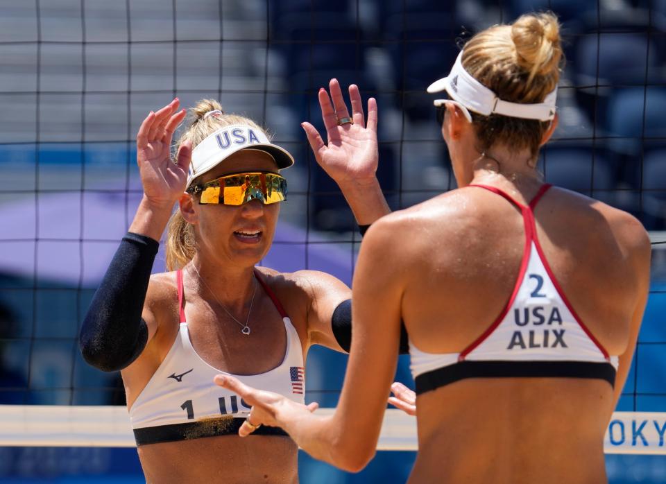 April Ross (USA) and Alix Klineman (USA) celebrate a point against Australia in the women's gold medal beach volleyball match at the Tokyo Olympics.