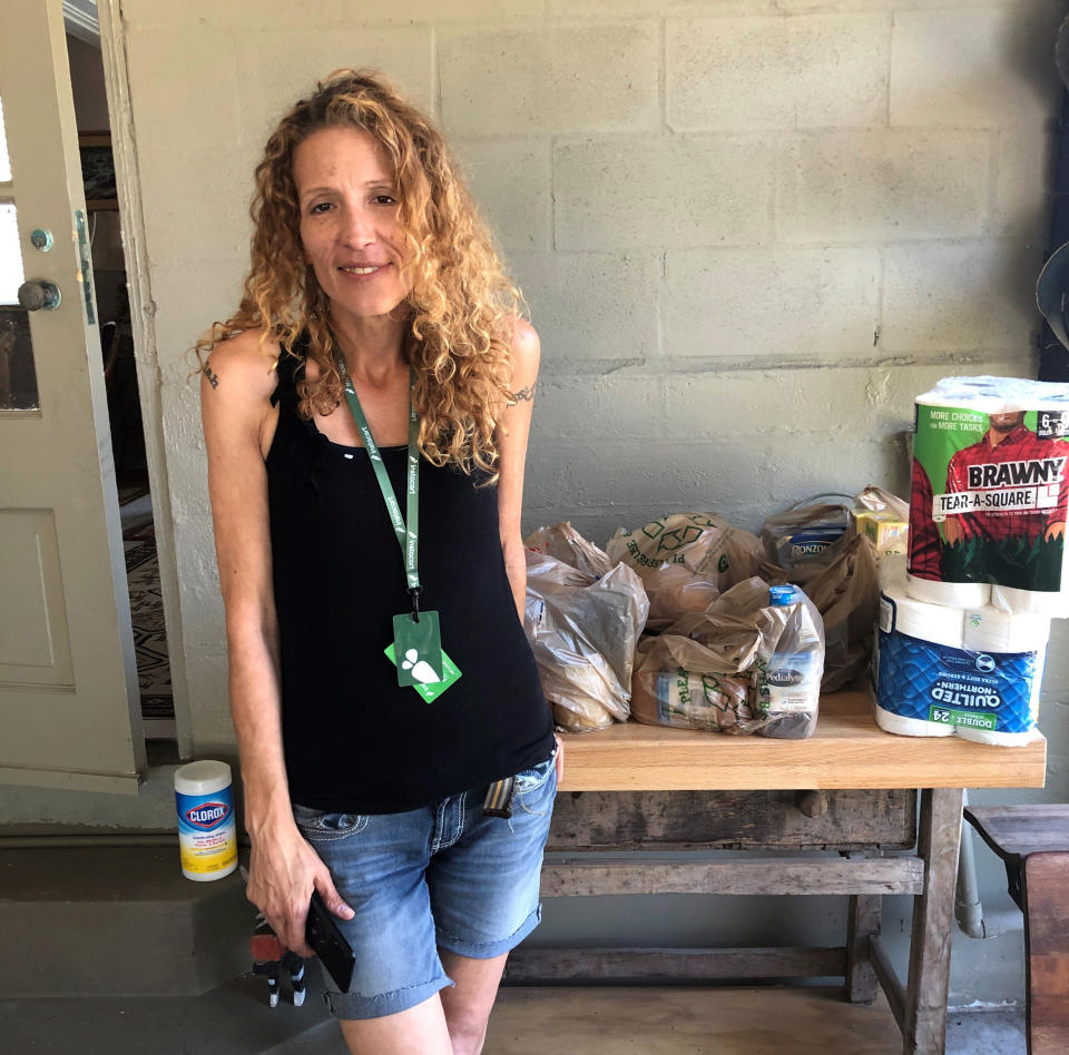 Instacart gig worker Summer Cooper, 39, delivers groceries, Saturday, March 28, 2020, in Belleair Beach, Fla. Cooper, 39, started working as an Instacart shopper in the Tampa Bay area in Florida recently after losing her position as a server at a hotel restaurant. (AP Photo/Curt Anderson)