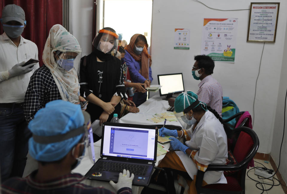 People register themselves to receive COVID-19 vaccine at a hospital in Prayagraj, India. Saturday, May 1, 2021. In hopes of taming a monstrous spike in COVID-19 infections, India opened vaccinations to all adults Saturday, launching a huge inoculation effort that was sure to tax the limits of the federal government, the country's vaccine factories and the patience of its 1.4 billion people. (AP Photo/Rajesh Kumar Singh)