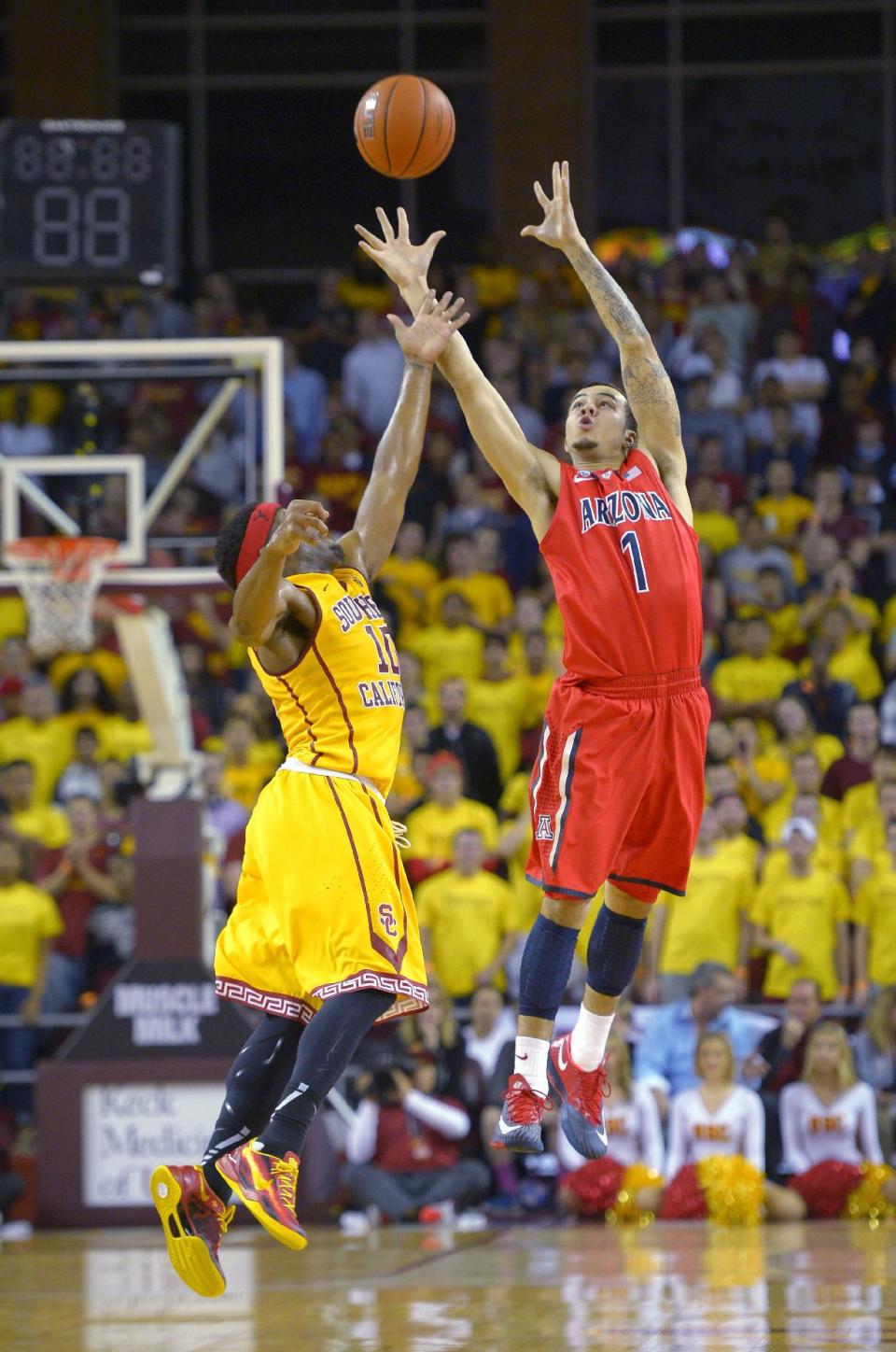 Arizona guard Gabe York, right, catches a pass as Southern California guard Pe'Shon Howard defends during the first half of an NCAA college basketball game, Sunday, Jan. 12, 2014, in Los Angeles. (AP Photo/Mark J. Terrill)