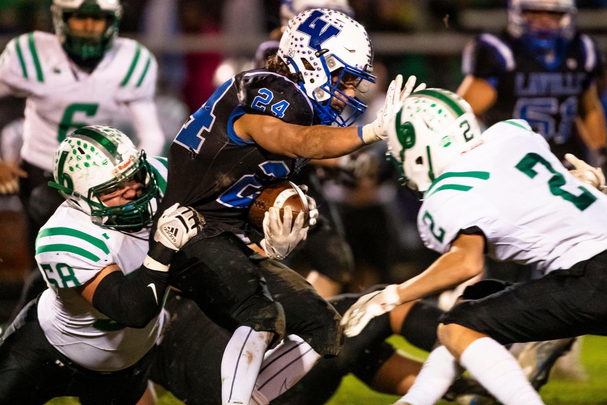 Laville's Cody Allen (24) tries to break Bremen's Josh Flora (2) and Sawyer Burks (58) tackles him during the Bremen vs. LaVille sectional championship football game Friday, Nov. 3, 2023 at LaVille High School in Lakeville.