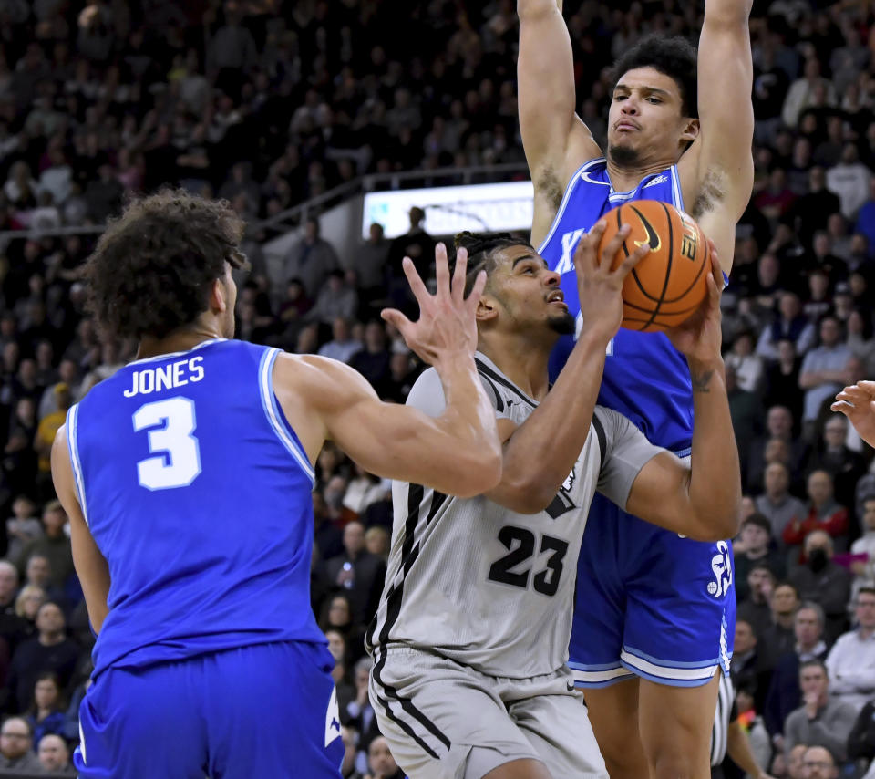 Providence forward Bryce Hopkins (23) is guarded by Xavier guard Colby Jones (3) and forward Cesare Edwards (4) during the second half of an NCAA college basketball game Wednesday, March 1, 2023, in Providence, R.I. (AP Photo/Mark Stockwell)