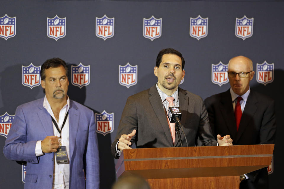 NFL vice president of officiating Dean Blandino, center, answers questions during a news conference, while Atlanta Falcons President & CEO and NFL competition committee member Rich McKay, back right, and Jeff Fisher, head coach of the St. Louis Rams and member of the NFL competition committee listen, at the NFL football annual meeting in Orlando, Fla., Monday, March 24, 2014. (AP Photo/John Raoux)