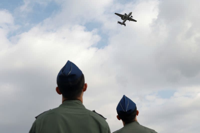Members of the Taiwan Air Force look on as an E-2K aircraft flies past during a demonstration for the media at the Pingtung air base in Pingtung
