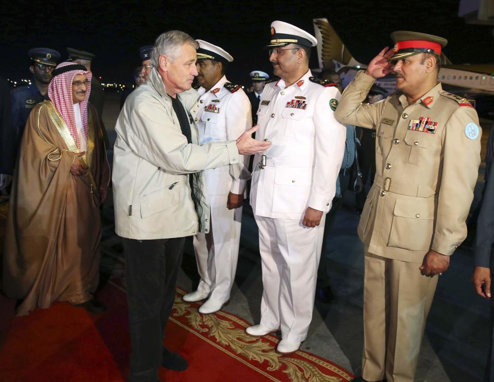 U.S. Secretary of Defense Hagel and Bahrain's Minister of State for Defense, Lt-Gen Dr. Shaikh Mohammed are greeted by members of the Bahrain military in Manama
