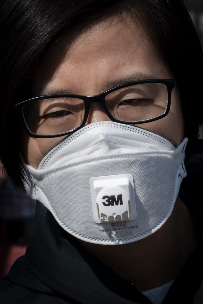 A woman wears a protective mask to reduce the effects of air pollution in Beijing (AFP Photo/NICOLAS ASFOURI)