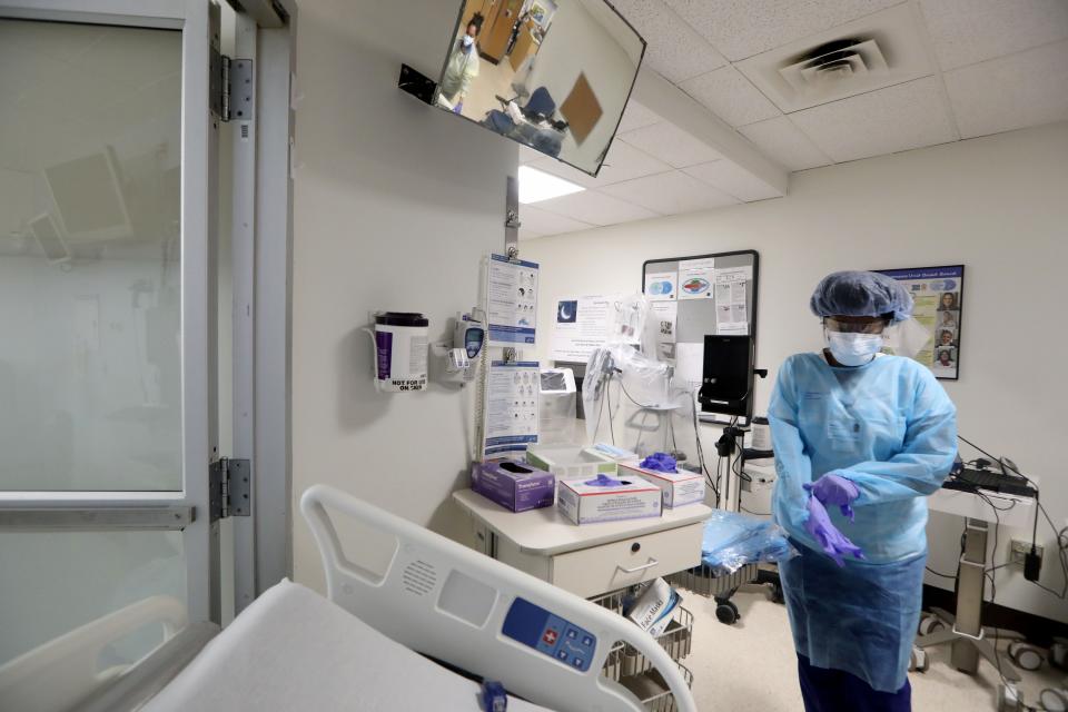 Vanessa Jean-Baptiste, a registered nurse in the intensive care unit at Northern Westchester Hospital in Mount Kisco, dons PPE equipment before entering the room of a patient with COVID-19 March 1, 2022. Two years into the COVID19 pandemic, Jean-Baptiste continues to work three 7:00 pm to 7:00 am shifts a week in the hospital's ICU.