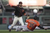 San Francisco Giants shortstop Brandon Crawford, top, throws to first base after forcing Baltimore Orioles' Adley Rutschman (35) out at second base on a double play hit into by Anthony Santander during the first inning of a baseball game in San Francisco, Saturday, June 3, 2023. (AP Photo/Jeff Chiu)