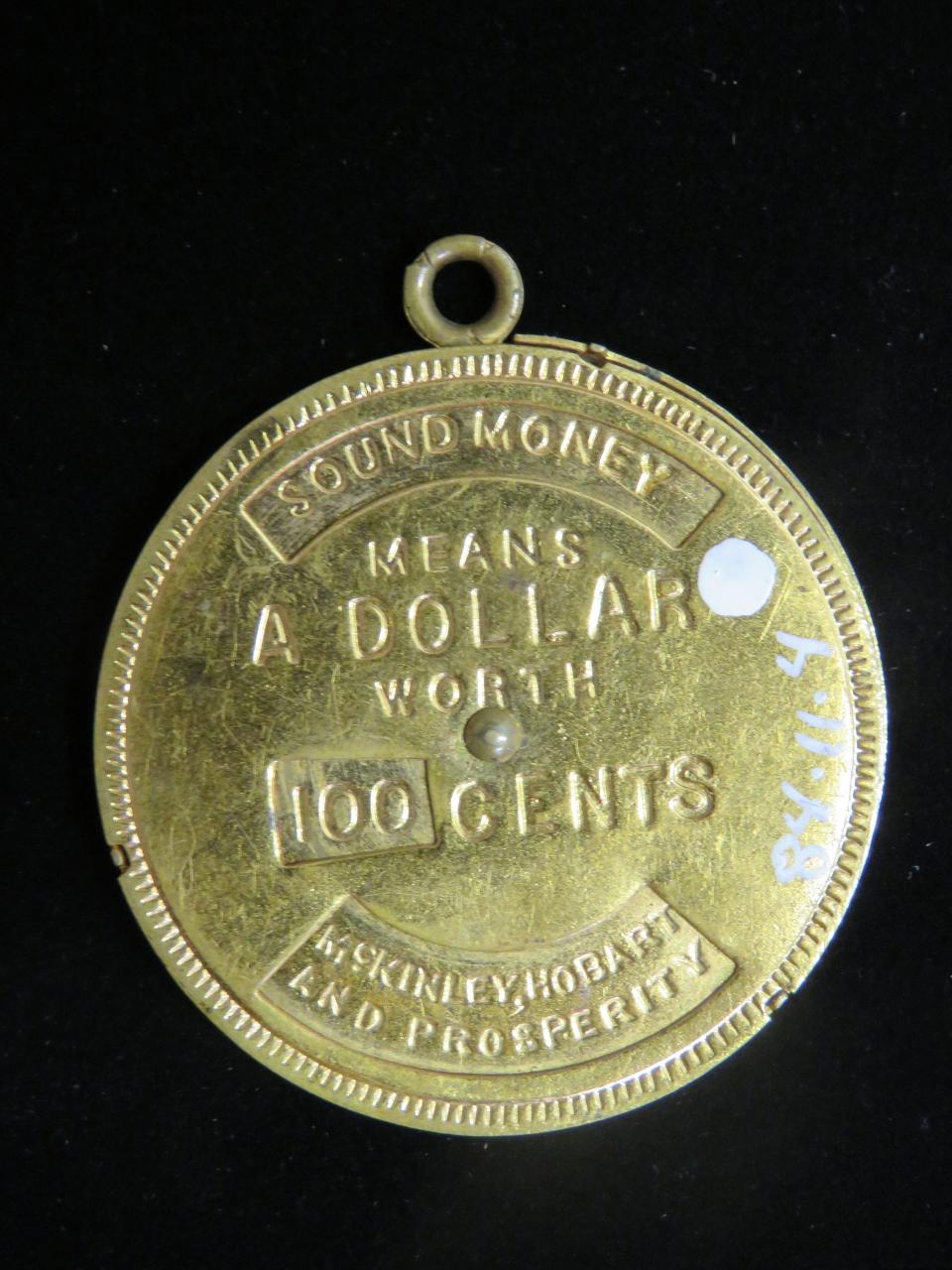 Kait Bergert, collections manager of McKinley Presidential Library & Museum, provided this artifact from the museum's collection to show President William McKinley's belief in "Sound Money" tied to gold. "Sound Money Means a Dollar (is) Worth 100 Cents," the inscription says.