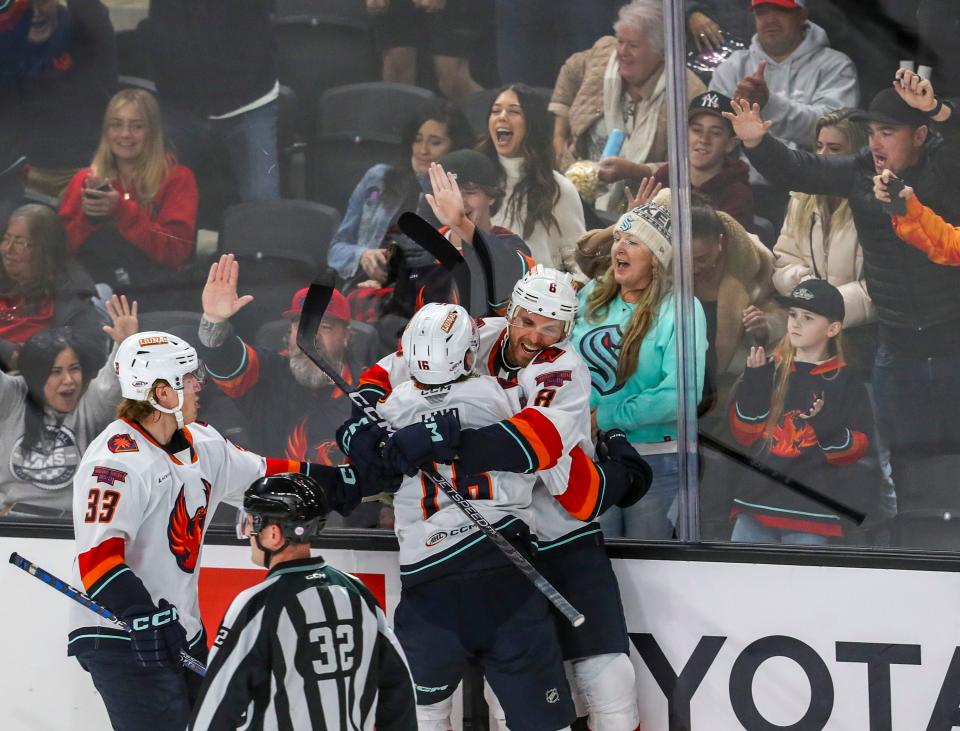 Coachella Valley defenseman Matt Tennyson (8) hugs forward Kole Lind (16) after Lind scores the first Firebirds goal of the game during the first period of their game at Acrisure Arena in Palm Desert, Calif., Tuesday, Dec. 20, 2022. 