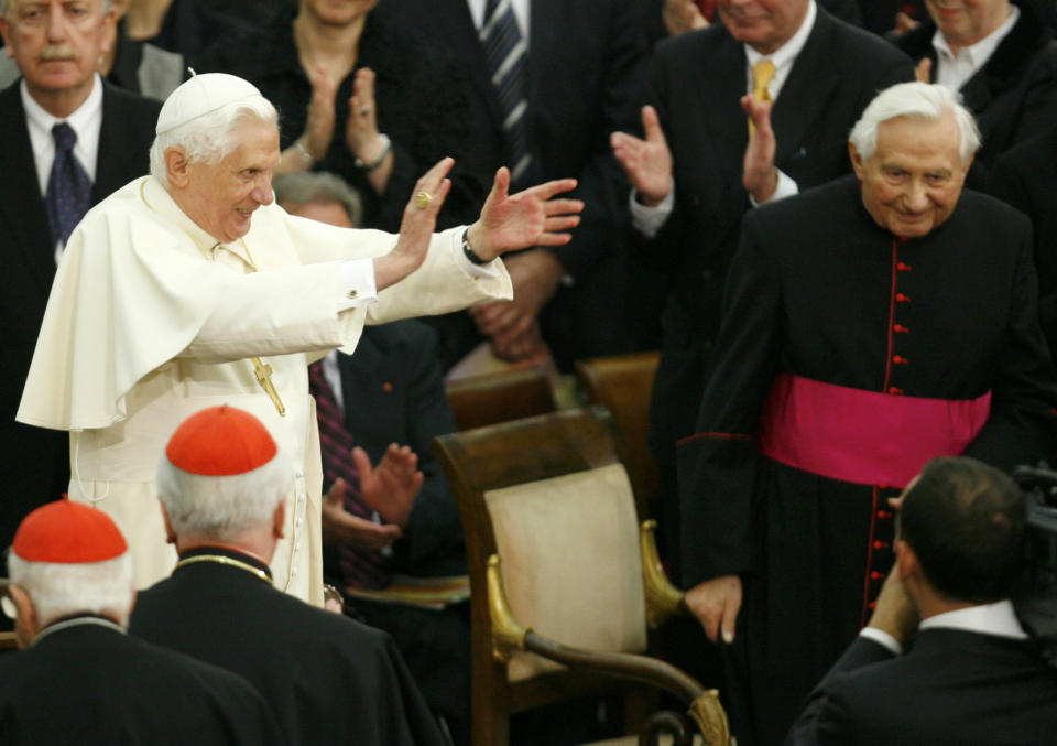 FILE - In this Saturday, Oct. 27, 2007 file photo, Pope Benedict XVI, center left, applauds, as his brother, Georg, right, looks on, during a concert by the German Symphonic Orchestra Bayerischer Rundfunk and the Bamberger Symphoniker, at the Paul VI Hall at the Vatican. The Rev. Georg Ratzinger, the older brother of Emeritus Pope Benedict XVI, who earned renown in his own right as a director of an acclaimed German boys’ choir, has died at age 96. The Regensburg diocese in Bavaria, where Ratzinger lived, said in a statement on his website that he died on Wednesday, July 1, 2020. (AP Photo/Andrew Medichini, File)