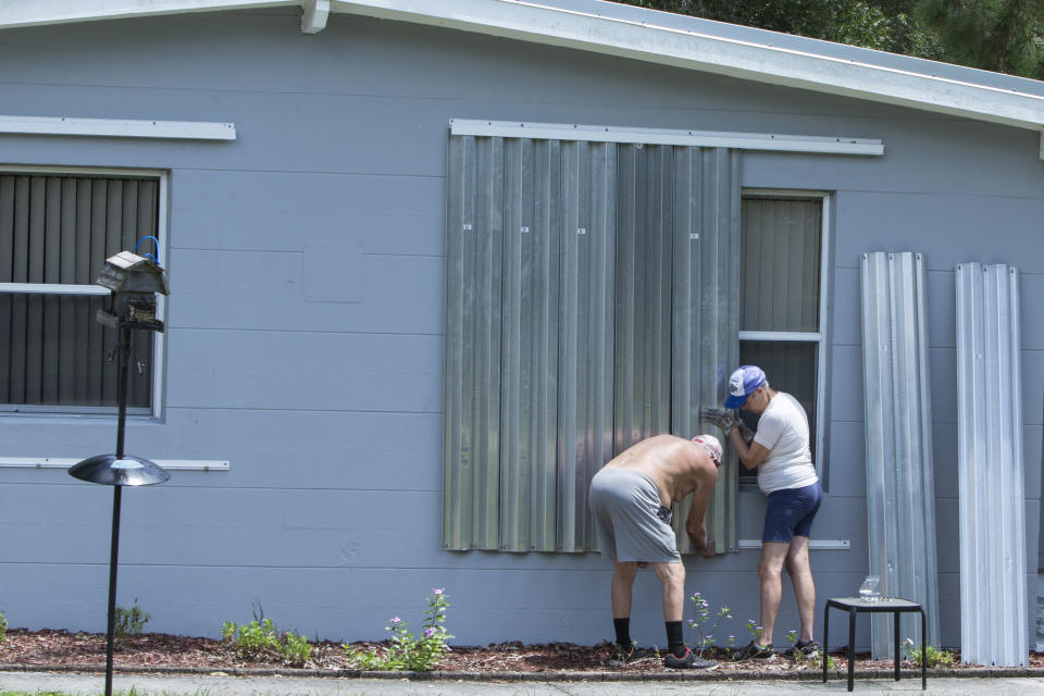 James Wolfe, 72, left, and Elaine Wolfe, 65, install shutters on their home in Vero Beach, Fla, Thursday, Aug. 29, 2019. The U.S. National Hurricane Center says Dorian could hit the Florida coast over the weekend as a major hurricane. (AP Photo/Ellis Rua)