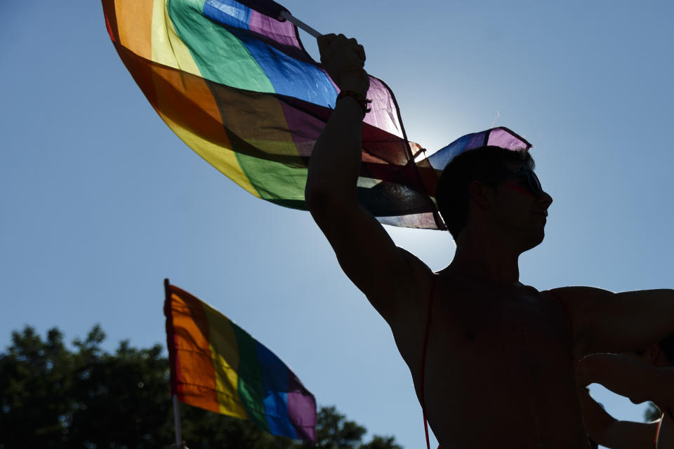 FILE - In this file photo dated Saturday, July 2, 2016, participants wave flags and dance during the Gay Pride parade in Madrid, Spain. The Spanish Cabinet on Tuesday June 29, 2021, passed a draft bill on LGBTQ rights that will seek parliamentary approval to allow transgender people over 16 years old to freely change their gender and name in the official registry without doctors or witnesses intervening in the process. (AP Photo/Daniel Ochoa de Olza, FILE)