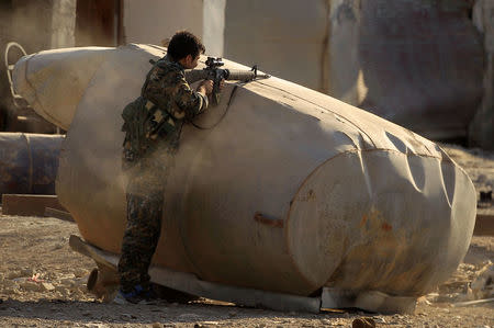 A member of the Syrian Democratic Forces shoots to detonate a mine found on the road during fighting with Islamic State militants in Raqqa. REUTERS/Zohra Bensemra