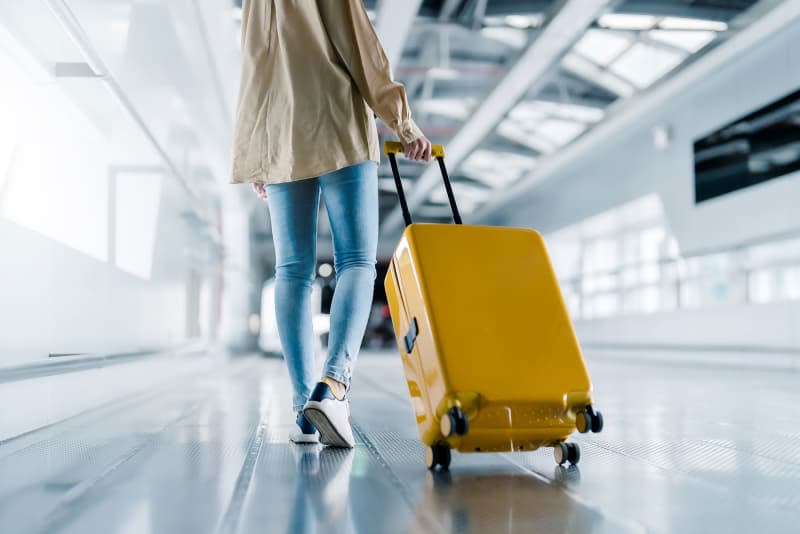 woman with luggage and walking in airport