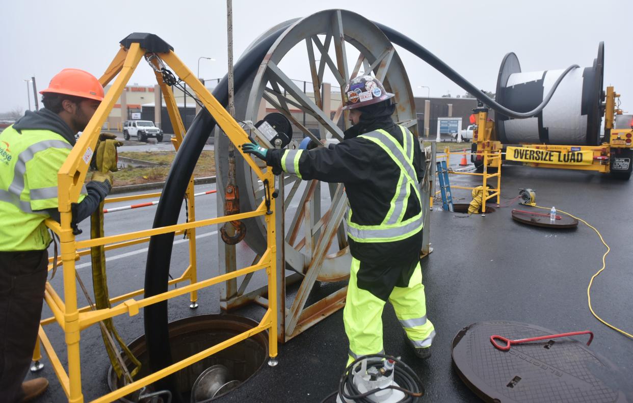 HYANNIS 01/05/23 Workers with Elecnor Hawkeye feed a large electric cable from a 3000 foot spool down into underground conduit where it is spliced together along Attuck's Lane in Hyannis. The cable will bring the electricity from the offshore Vineyard Wind project to a substation located off Independence Drive.  Steve Heaslip/Cape Cod Times 