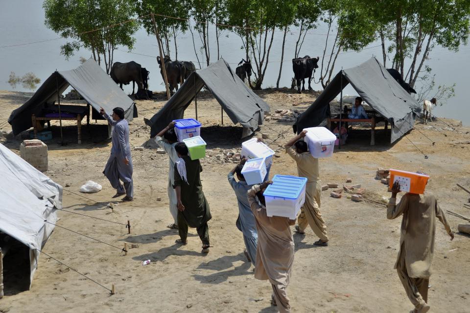 Volunteers of a charity group arrive to distribute food among flood victims at a camp, in Jaffarabad, a flood-hit district of Baluchistan province, Pakistan, Thursday, Sept. 15, 2022. The devastating floods affected over 33 million people and displaced over half a million people who are still living in tents and make-shift homes. The water has destroyed 70% of wheat, cotton and other crops in Pakistan. (AP Photo/Zahid Hussain)