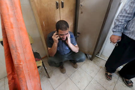 A Palestinian reacts as he speaks on the phone at a hospital following an explosion in Rafah in the southern Gaza Strip August 6, 2015. REUTERS/Ibraheem Abu Mustafa