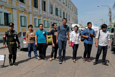 Seven of the eight people charged with ridiculing junta leader Prayuth Chan-ocha pose for photographers as they arrive at the military court in Bangkok, Thailand, August 23, 2016. REUTERS/Chaiwat Subprasom