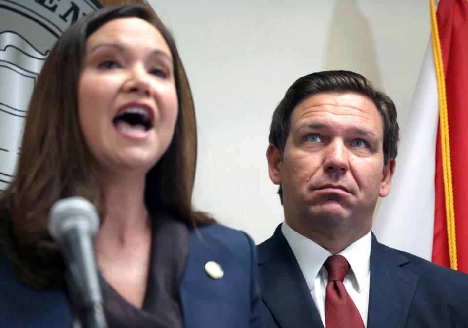 Florida Governor Ron DeSantis listens to Florida Attorney General Ashley Moody during a press conference in Orlando on Aug. 26, 2021.