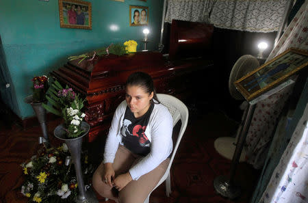 A relatives sit next to the coffin of Darwin Manuel Urbina, 29, who according to nation's Red Cross was shot dead during a protest over a controversial reform to the pension plans of the Nicaraguan Social Security Institute (INSS) in Managua, Nicaragua April 21, 2018. REUTERS/Jorge Cabrera