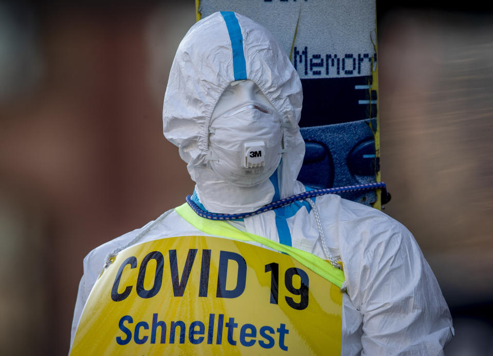 FILE - In this March 7, 2021 file photo an advertising figure for Covid-19 rapid test stands in front of a small test center in Frankfurt, Germany. (AP Photo/Michael Probst, file)