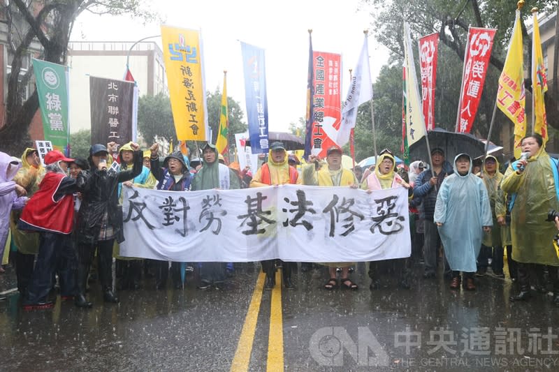 勞團8日在立院周邊抗議勞基法修法，參與的勞工在雨中呼口號。（中央社）