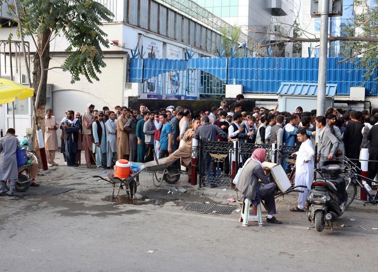 Afghans wait in long lines for hours to try to withdraw money, in front of Bank in Kabul, Afghanistan on Aug. 30, 2021.