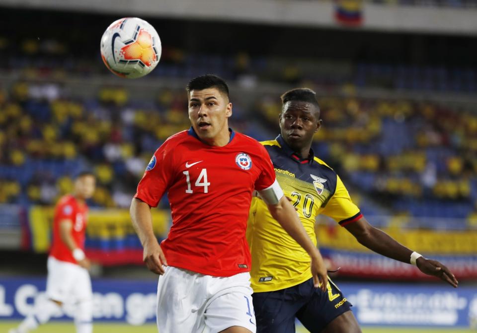 El chileno Tomás Alarcón (izquierda) y el ecuatoriano Alejandro Cabeza (derecha) pugnan por el balón durante el partido del Preolímpico Sudamericano de fútbol en Pereira, Colombia, el sábado 18 de enero de 2020. (AP Foto/Fernando Vergara)