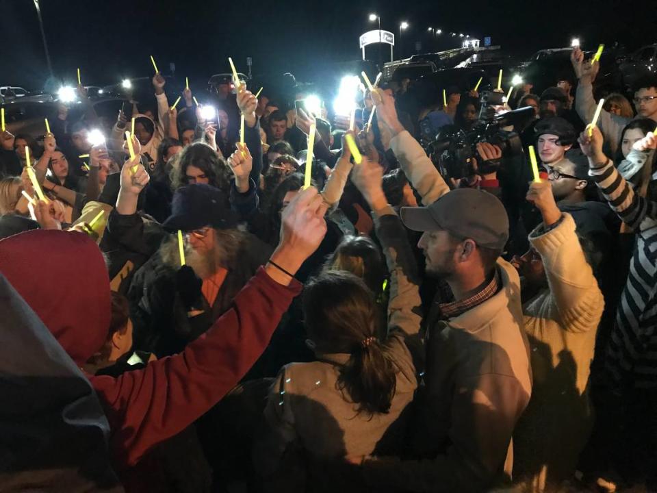Friends and family of shooting victim Madison Harris, 16, of Biloxi hold up glow sticks during a candlelight vigil beside the beach at the Biloxi Lighthouse. Five teens were charged with capital murder in the case after Madison died Monday during surgery.