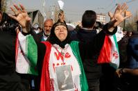 <p>An Iranian woman wearing a portrait of Supreme leader Ayatollah Ali Khamenei around her neck and the colours of the national flag shouts slogans during a pro-government march held after the weekly Friday prayers in central Tehran on Jan. 5, 2018. (Photo: Atta Kenare/AFP/Getty Images) </p>