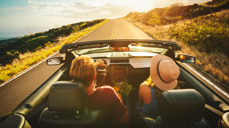 Happy Young Couple Driving Along Country Road in Convertible at Sunset - Image.