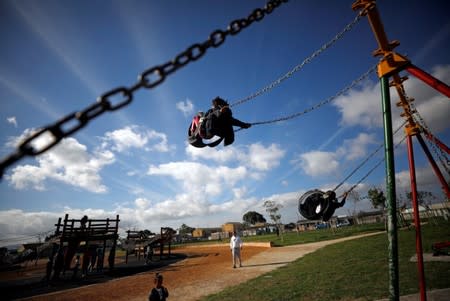 Children play as community members gather in a park to discuss gang violence in Manenberg township, Cape Town