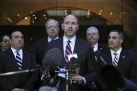 United States Attorney Andrew Lelling, center, speaks outside federal court after the sentencing hearing for Insys Therapeutics founder John Kapoor, Thursday, Jan. 23, 2020, in Boston. Kapoor was sentenced to spend 5 1/2 years in prison for orchestrating a bribery and kickback scheme prosecutors said helped fuel the opioid crisis. He was found guilty the previous May of racketeering and conspiracy in a scheme where millions of dollars in bribes were paid to doctors across the United States to prescribe the company's highly addictive oral fentanyl spray, known as Subsys. (AP Photo/Charles Krupa)