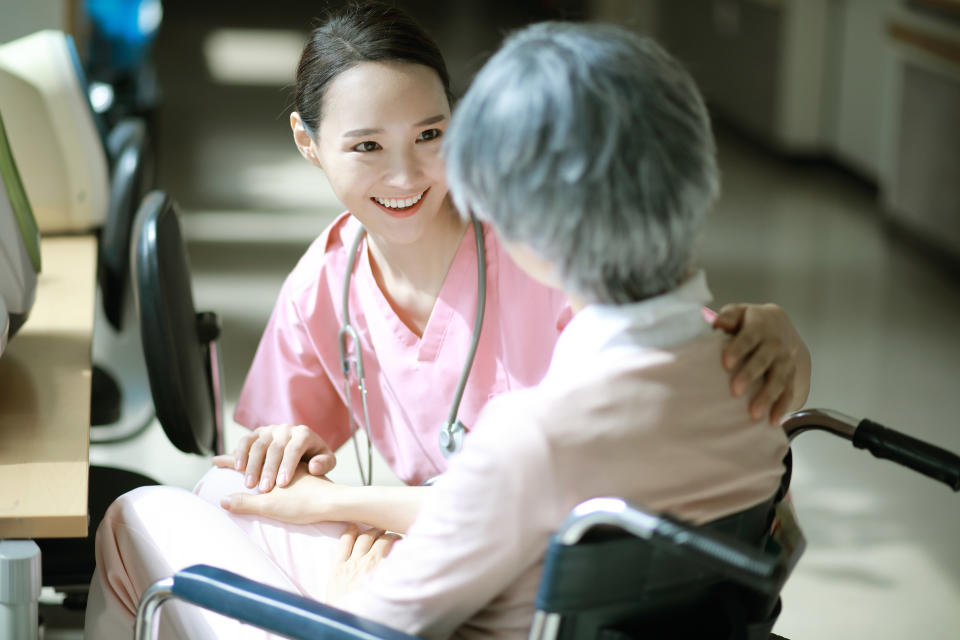 Nurse talking to senior woman in wheelchair