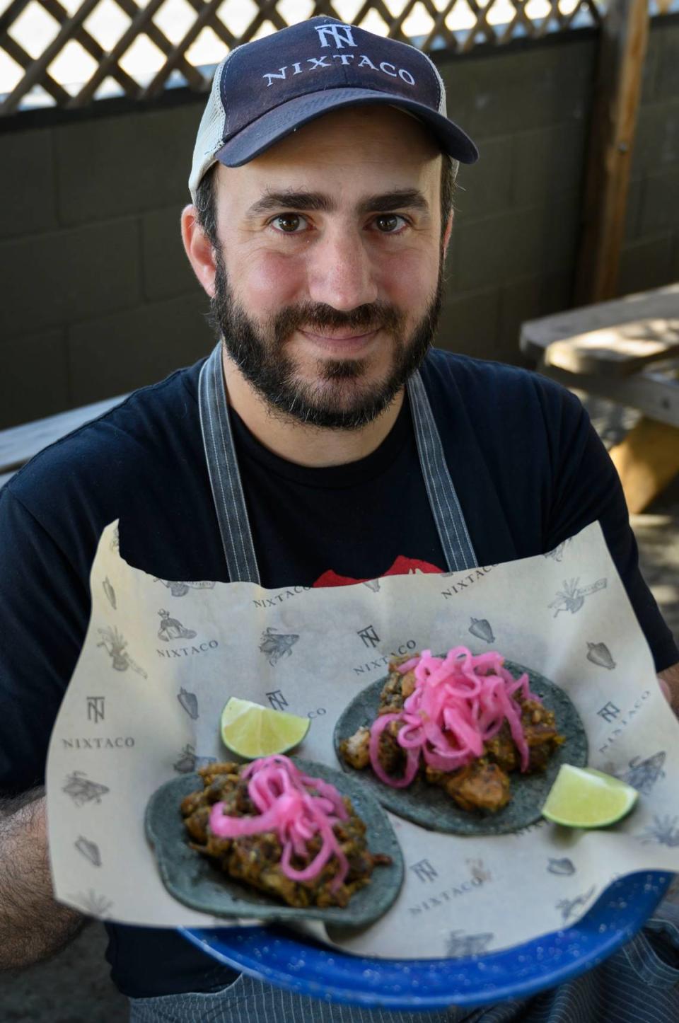 Patricio Wise, chef and proprietor at Nixtaco in Roseville, holds a plate of chicharron tacos in 2019. The renowned Mexican restaurant retained its Bib Gourmand status for the coming year.