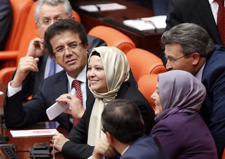 Turkey's ruling Ak Party (AKP) lawmakers Nurcan Dalbudak (C) and Sevde Beyazit Kacar (R) attend the general assembly wearing their head scarves at the Turkish Parliament in Ankara October 31, 2013. REUTERS/Umit Bektas