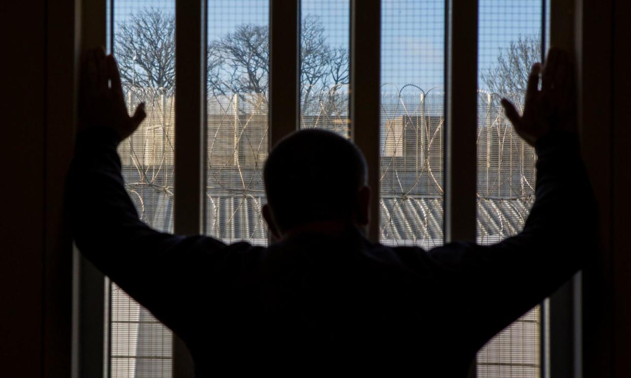 <span>A prisoner staring out of a window at HMP/YOI Portland, Dorset, United Kingdom.</span><span>Photograph: Andrew Aitchison/Corbis/Getty Images</span>
