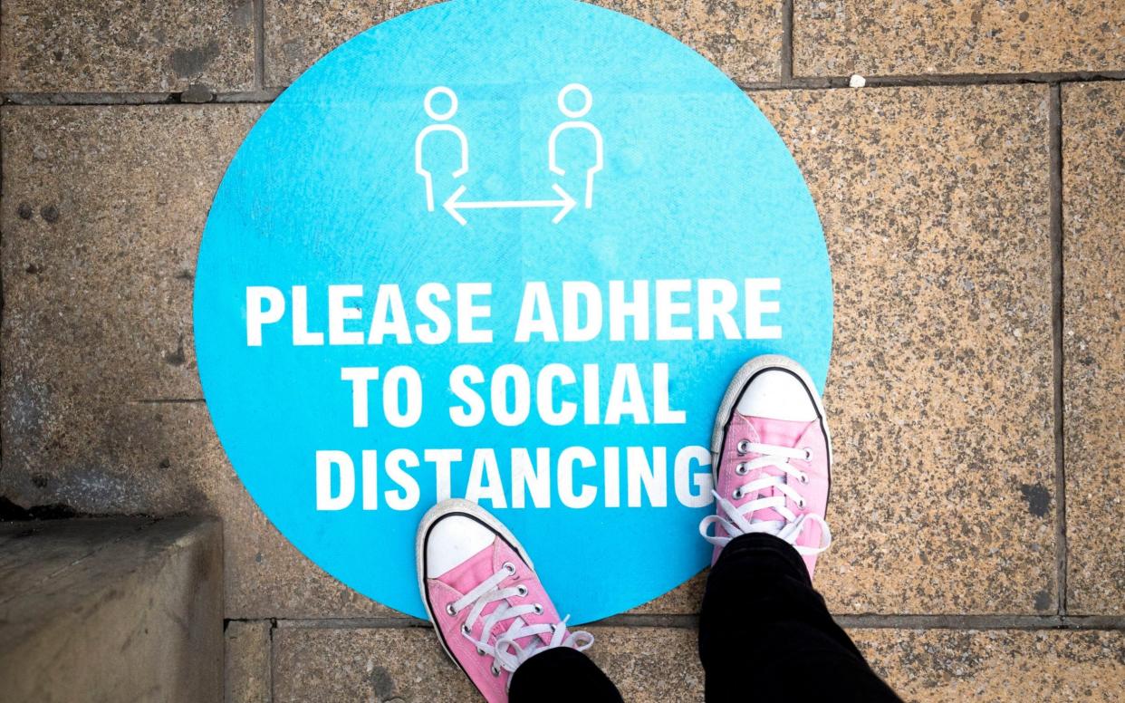 Social distancing sign outside a shop on the pavement in Edinburgh's Princes Street - PA