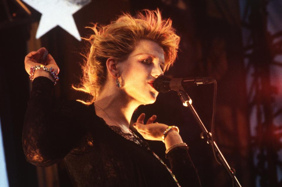 Courtney Love in lace top performing with a microphone onstage