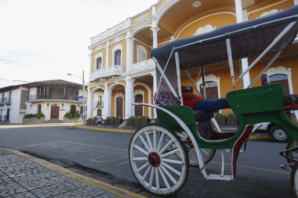 A coach driver takes a nap as he waits for tourists in the colonial city of Granada, Nicaragua, Monday, Sept. 10, 2018. The U.S., Canada, Spain and England, issued travel warnings urging their citizens to avoid travel to Nicaragua. (AP Photo/Alfredo Zuniga)