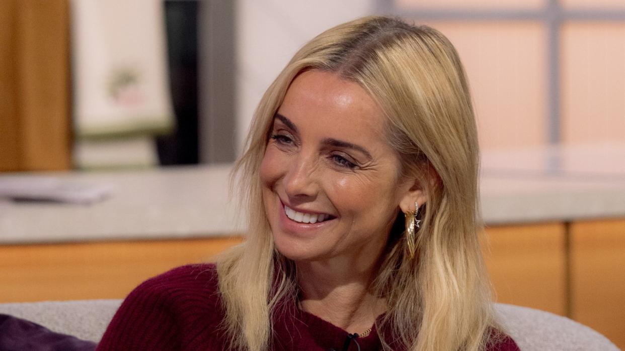 Louise Redknapp smiling in a red jumper