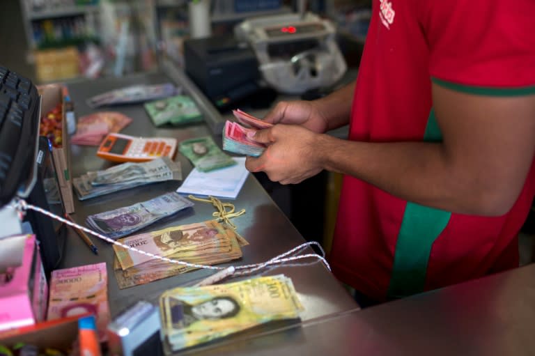 A Brazilian shopkeeper counts almost worthless Venezuelan bolivars brought by people fleeing acute shortages of basic goods back home
