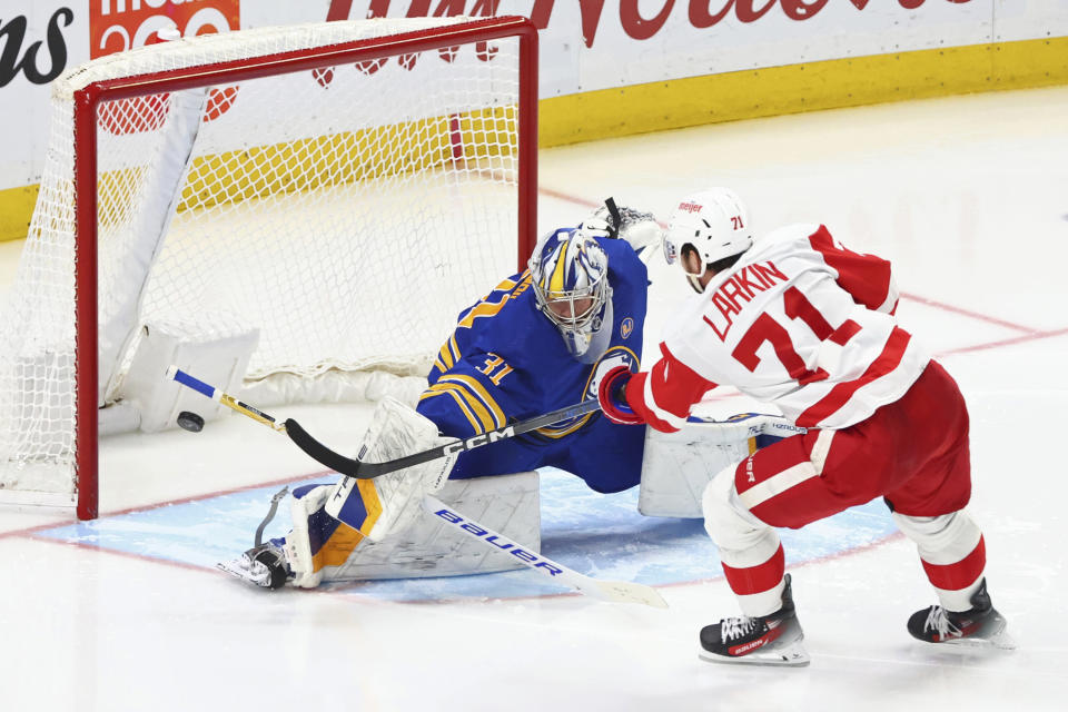 Buffalo Sabres goaltender Eric Comrie (31) stops Detroit Red Wings center Dylan Larkin (71) during the third period of an NHL hockey game Tuesday, Dec. 5, 2023, in Buffalo, N.Y. (AP Photo/Jeffrey T. Barnes)