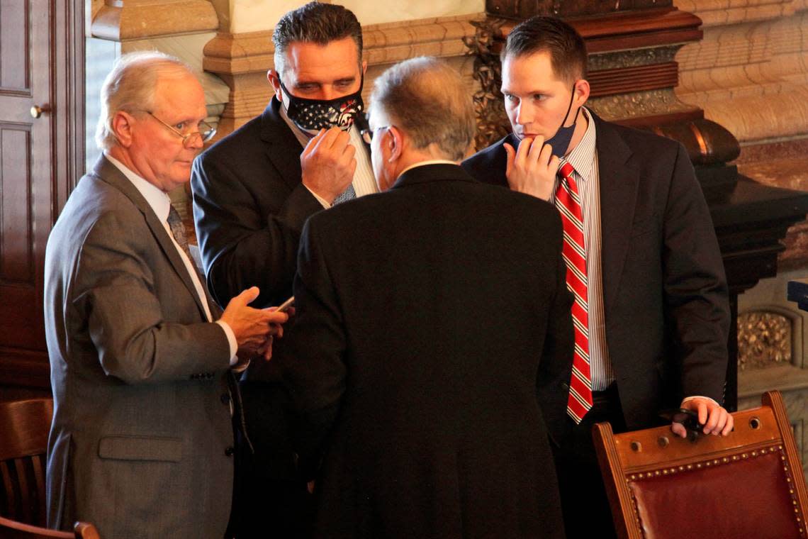 ‘Clockwise from the far left, former Senate Majority Leader Gene Suellentrop, R-Wichita; Senate President Ty Masterson, R-Andover; Chase Blasi, Masterson’s operations chief, and Sen. Mike Thompson, R-Shawnee, confer in the Kansas Senate during a debate on a bill rewriting the state’s emergency management laws that includes a provision to prevent the governor from closing K-12 schools, Monday, March 1, 2021, in Topeka.